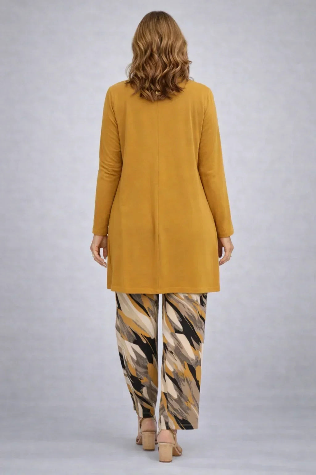 Honora mustard three-piece set back view with the long cardigan and mustard, cream and black print trousers