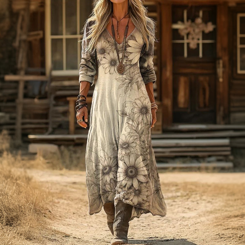 Lenora botanical sketch maxi dress worn with brown boots, showing the uneven hem