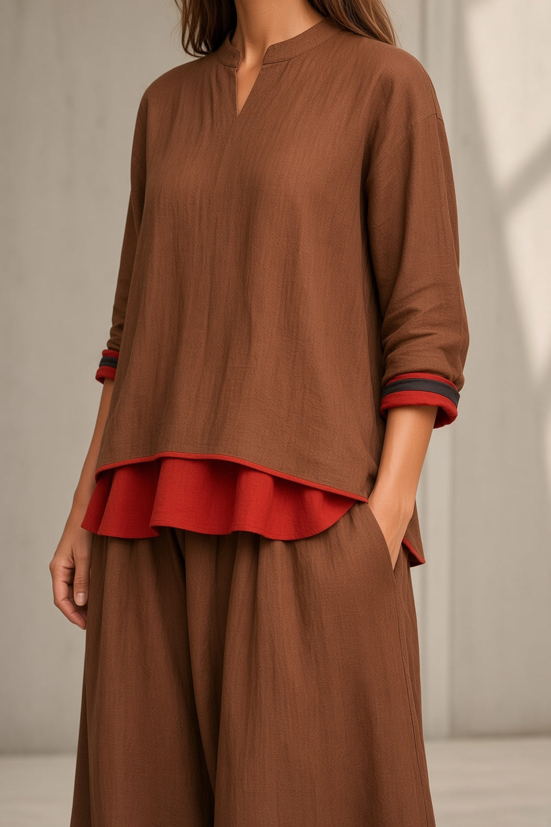 Tamsin tunic and wide-leg pant set in brown, detail of red layered hem and striped cuffs